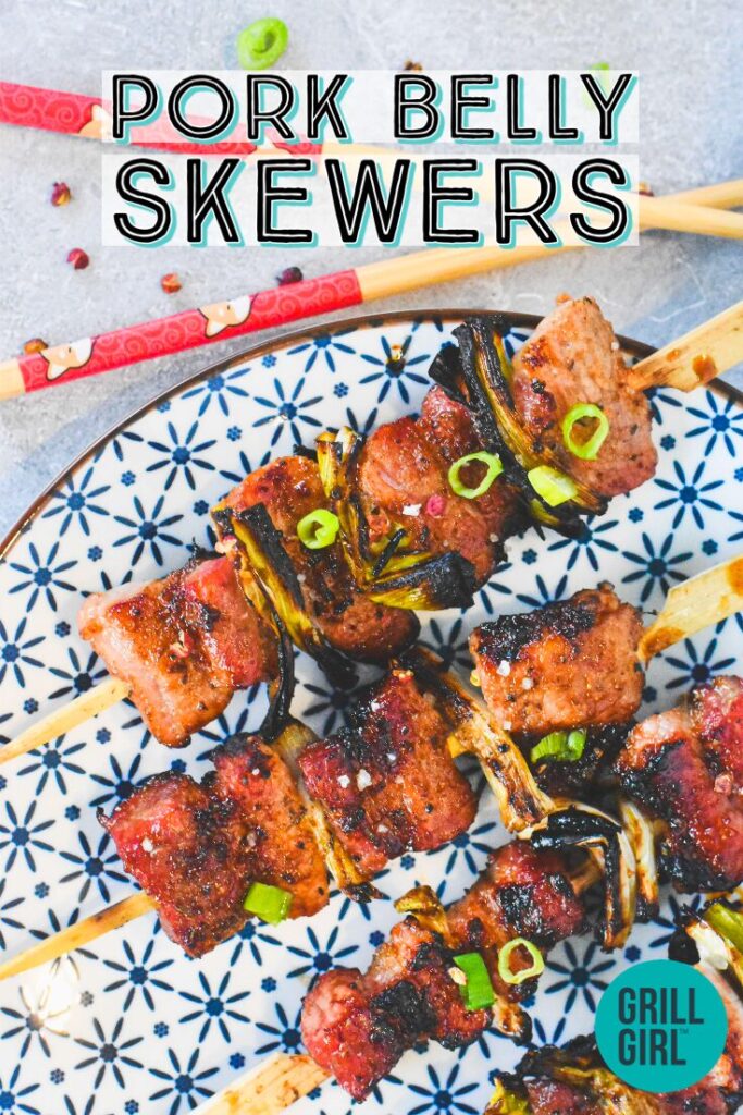 Pork belly on skewers garnished with scallions and shown with chopsticks.