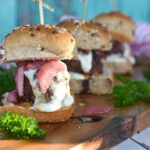 Three lamb sliders with whipped feta, pickled onions, and pomegranate molasses.